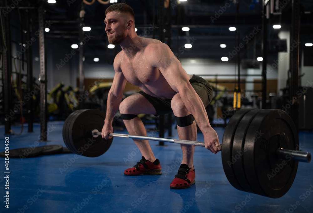 Sweaty sportsman doing snatch exercise with barbell Sweaty sportsman doing snatch exercise with barbell