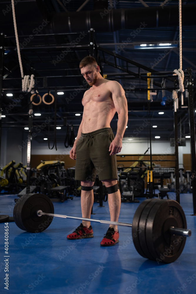 Weightlifter looking at barbell during training Weightlifter looking at barbell during training