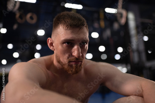 Determined male athlete resting in gym photo