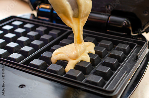 Modern waffle maker with ingredients, homemade Belgian waffles photo