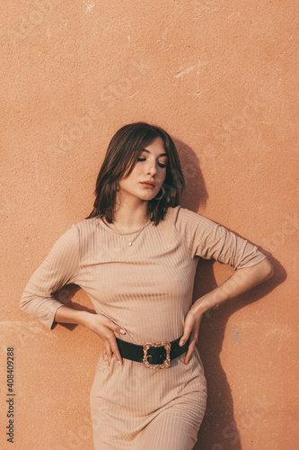 Portrait of a beautiful woman in a orange wall photo