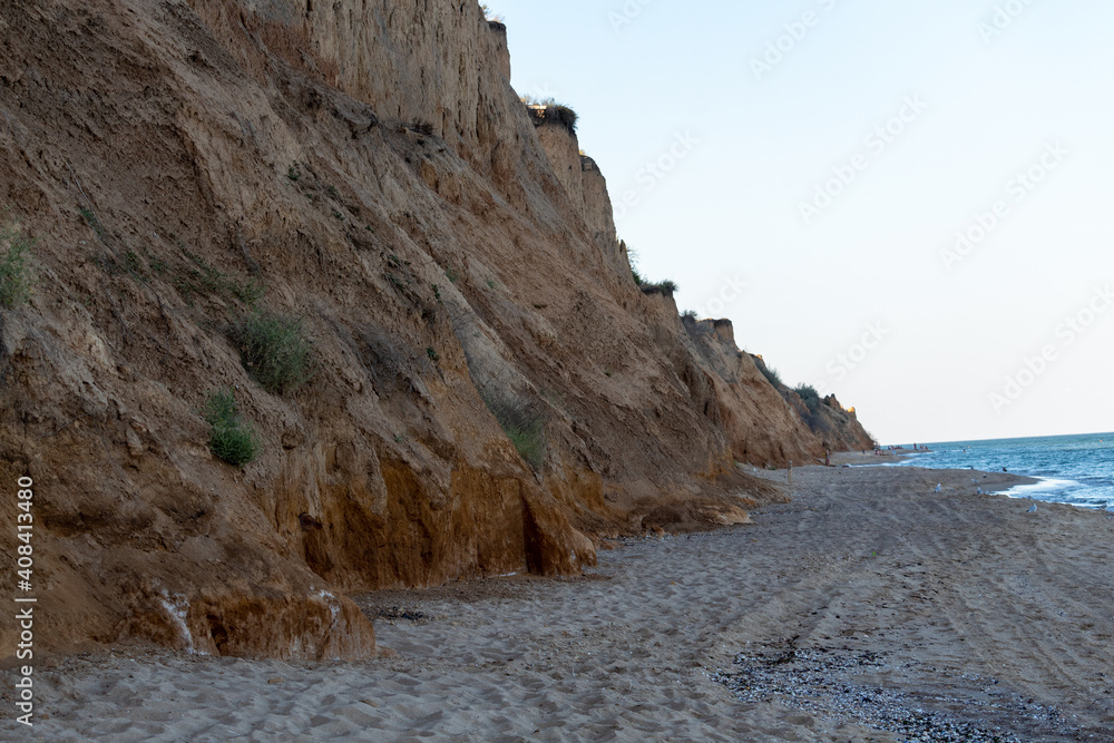 The Black Sea coast, sandy cliff and blue sky with single clouds in summer sunny day. Sanzhiika, Odessa region, Ukraine.