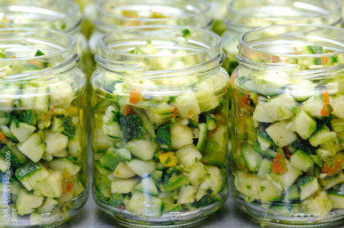 zucchini and vegetables in oil in glass jar