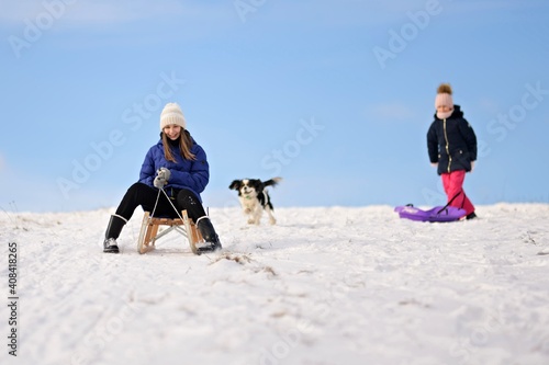 Cute children and dog playing in snow