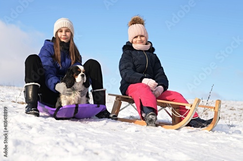 Cute children and dog playing in snow