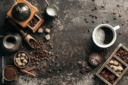 Coffee cup with coffee grinder and coffee beans on dark textured background. photo