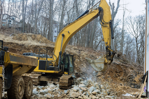Heavy trucks with moving stone rock in a construction site on load gravel excavator