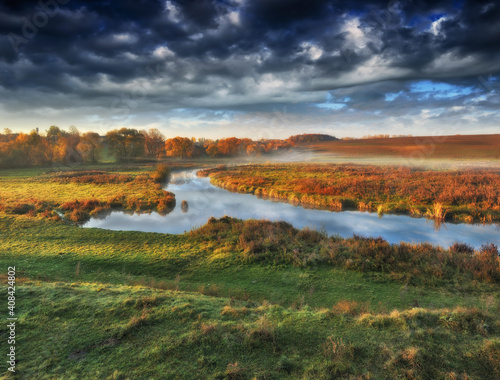 picturesque clouds over the river. autumn sunrise in the meadow