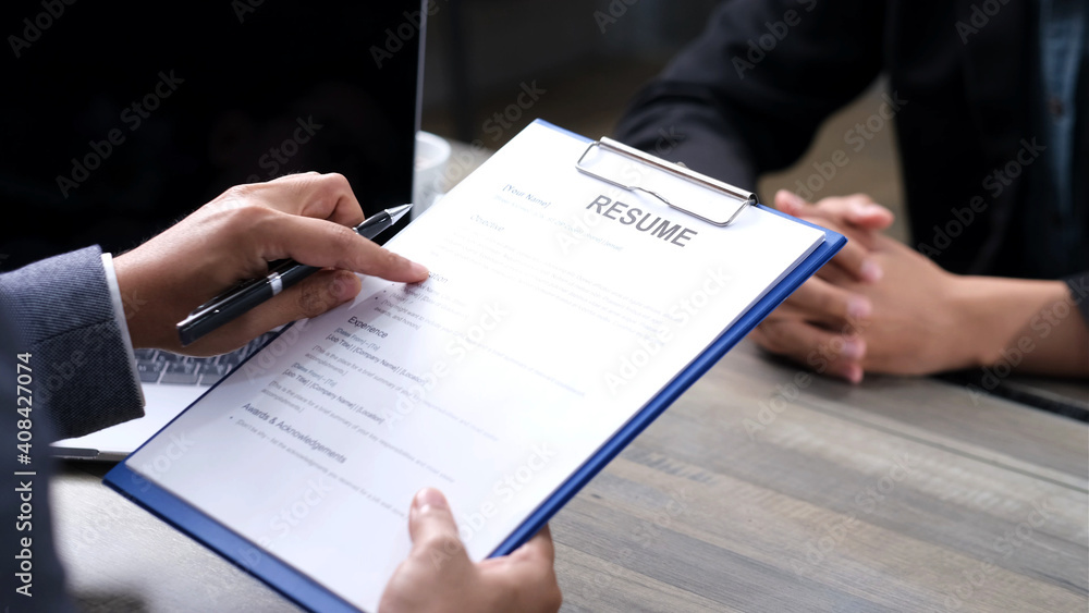 Businessman hand holding resume when interview the applicant at office background, job search, job interview, business concept Businessman hand holding resume when interview the applicant at office background, job search, job interview, business concept