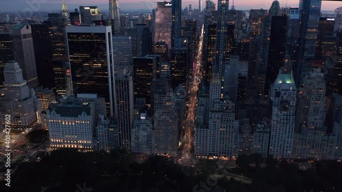 Above Central Park at Night with View over New York City Skyline and countless flashing lights in Urban Jungle of Manhatta, Aerial Wide View Dolly forward