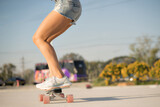 Close-up Asian women surf skate or skates board outdoors on beautiful summer day. Happy young women play surf skate at park on morning time.