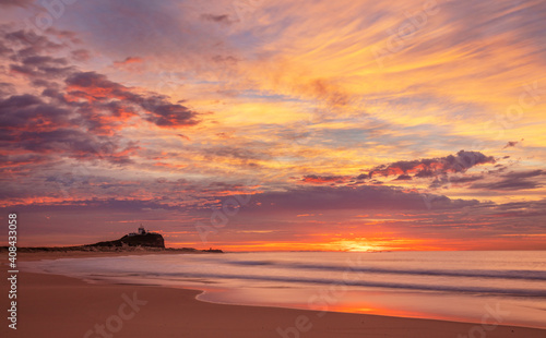 Beautiful winters sunrise over Nobbys Beach. Nobbys Lighthouse in the distance. Newcastle ,Hunter Region of N.S.W. Australia.