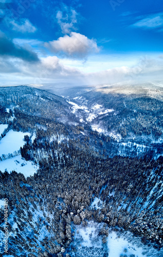 Beautiful panoramic aerial drone view on a winter landscape in the Stolowe mountains during a snowfall. The Stolowe Mountains National Park, Poland, Europe