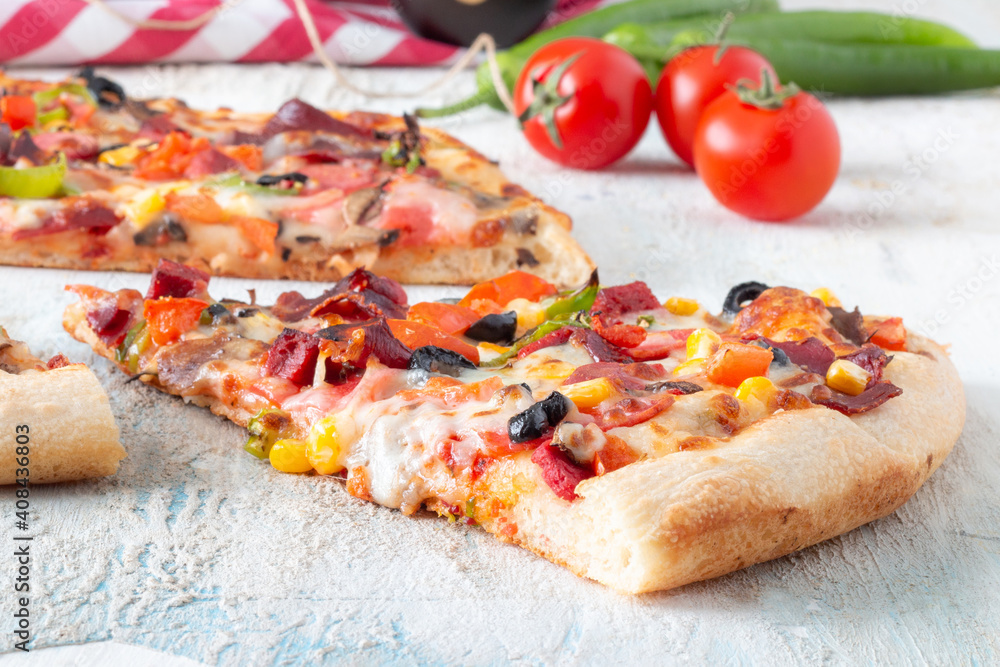 pizza slice with salami and vegetables