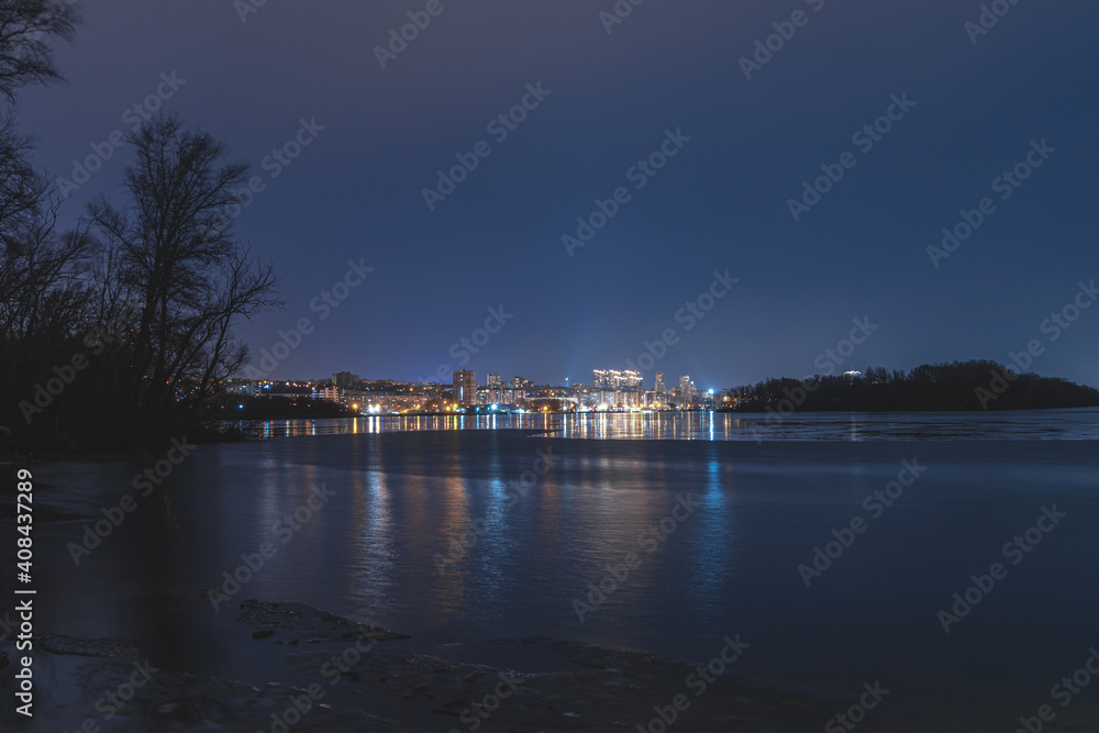 Beautiful city at night. Night city reflected in the water.