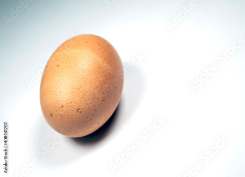 Single, brown, speckled, chicken egg isolated on white background, macro