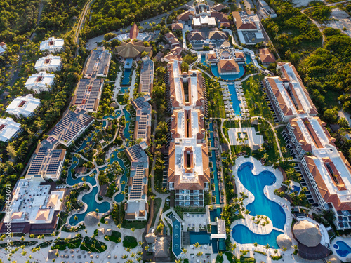 Aerial drone view of beach resort hotels with pools, umbrellas and blue water of Atlantic Ocean, Bavaro, Punta Cana, Dominican Republic