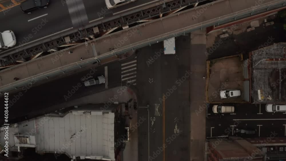 Top down birds eye overhead view of speeding emergency services ambulance truck driving under overpass and overtaking public transportation bus in New York City Top down birds eye overhead view of speeding emergency services ambulance truck driving under overpass and overtaking public transportation bus in New York City
