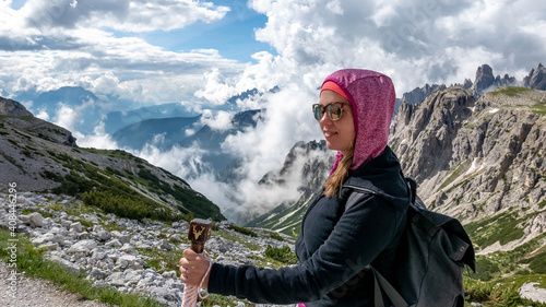 Beautiful shot of female hiking in the mountain cliffs with a mesmerizing cloudsc photo