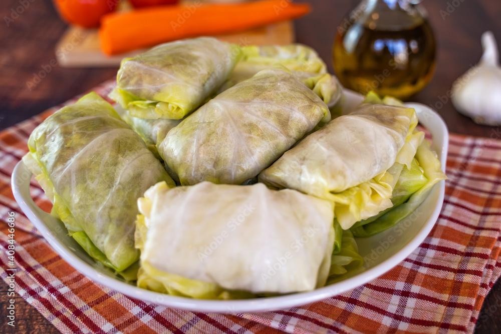 Raw cabbage rolls (stuffed cabbage) with meat and rice on a white plate. Close-up Raw cabbage rolls (stuffed cabbage) with meat and rice on a white plate. Close-up