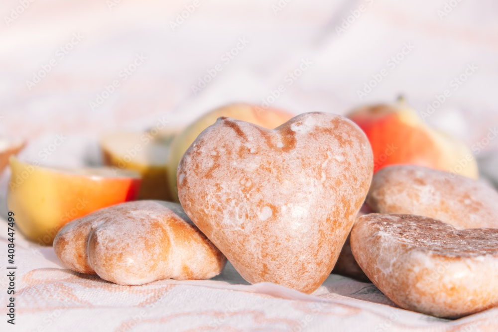 Glazed gingerbread cookies in the shape of heart.Picnic in nature, light snack with apples and cookies.Selective focus.