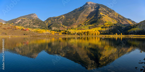 Autumn at Beaver Lake - A panoramic view of Whitehouse Mountain reflecting in calm Beaver Lake on a sunny Autumn evening, Marble, Colorado, USA.