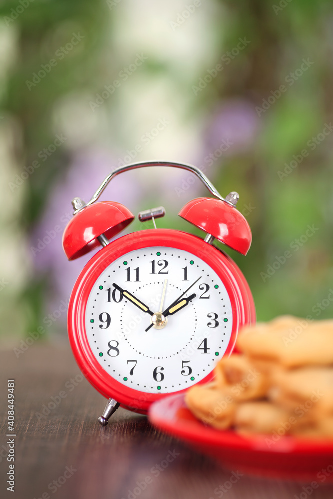 Vertical composition: a plate of fried spring rolls and an alarm clock Vertical composition: a plate of fried spring rolls and an alarm clock