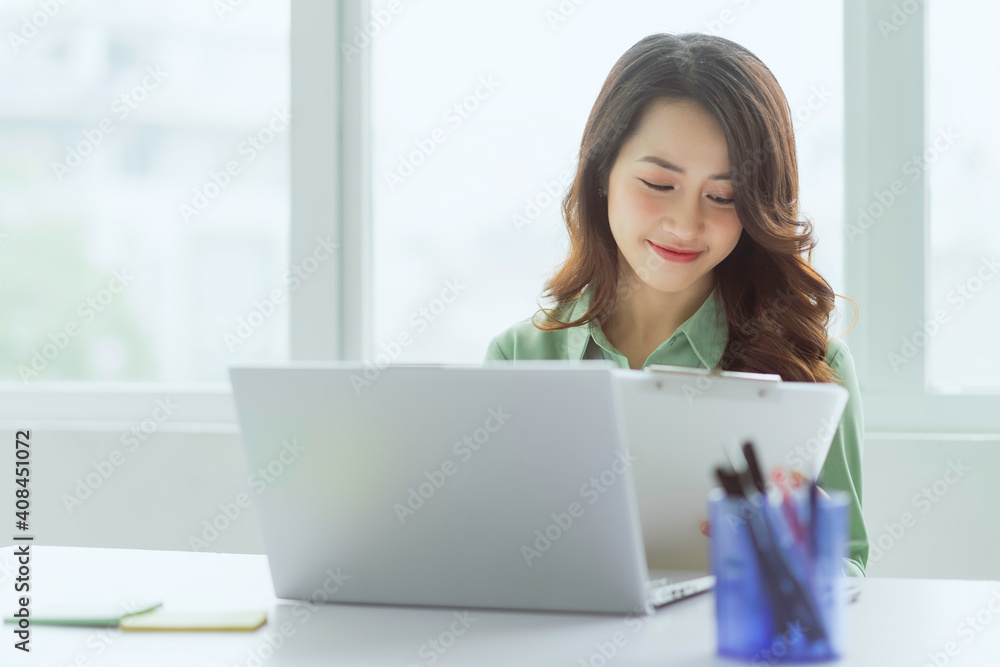 Beautiful Asian businesswoman sitting working at office Beautiful Asian businesswoman sitting working at office