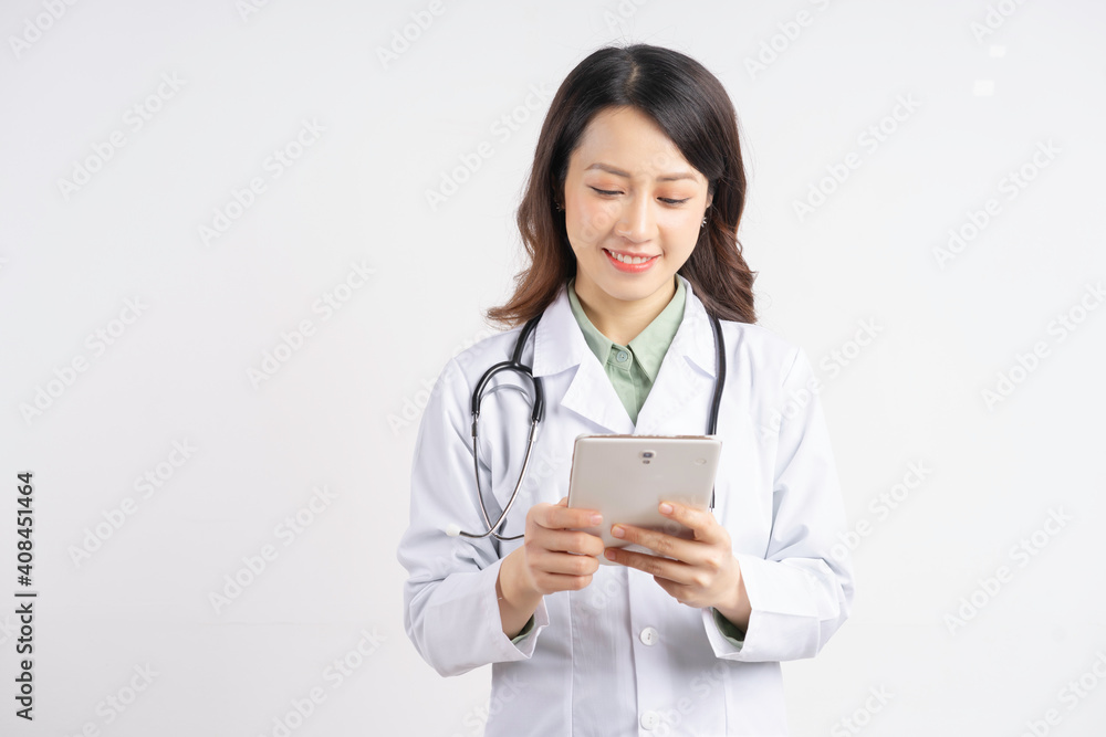 Portrait of asian female doctor using tablet standing smiling on white background Portrait of asian female doctor using tablet standing smiling on white background