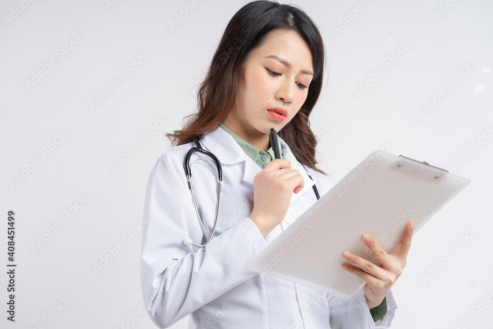 Beautiful Asian female doctor reading the document with a thoughtful expression Beautiful Asian female doctor reading the document with a thoughtful expression