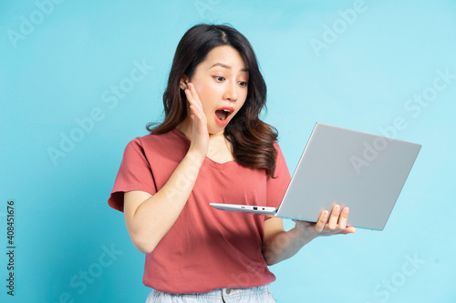 Beautiful Asian woman using laptop with a surprised face