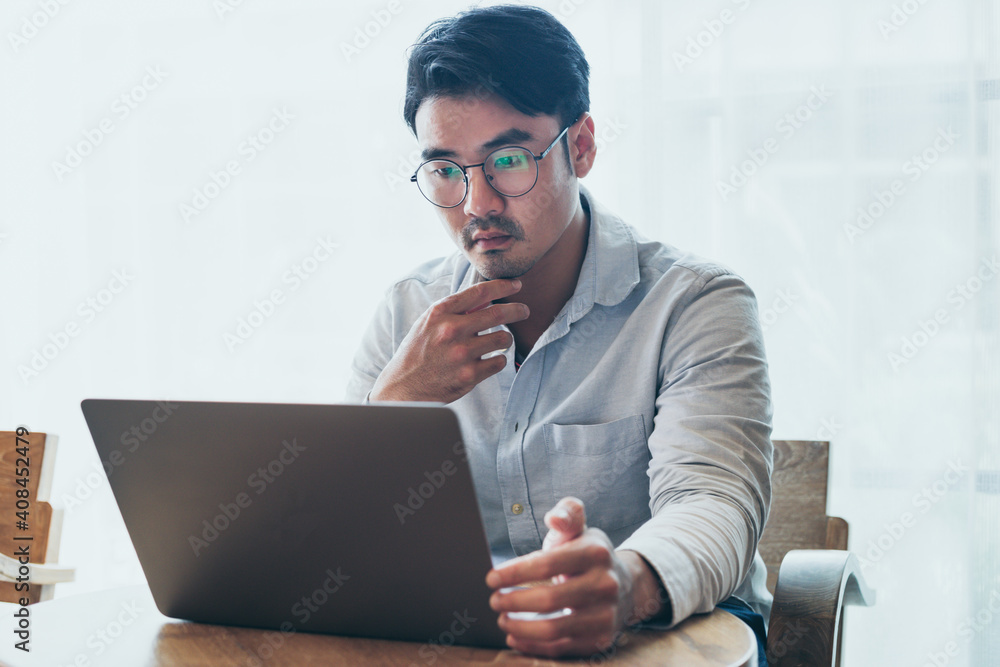 © panitan - asian man work using computer hand typing laptop keyboard contact us.student study learning education online.adult professional people chatting search at office.concept for technology device business