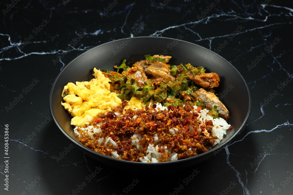 Classic cooked jasmine rice topping with crispy fish paste serving on the plate. Famous comfortable food menu in Asia. Classic cooked jasmine rice topping with crispy fish paste serving on the plate. Famous comfortable food menu in Asia.