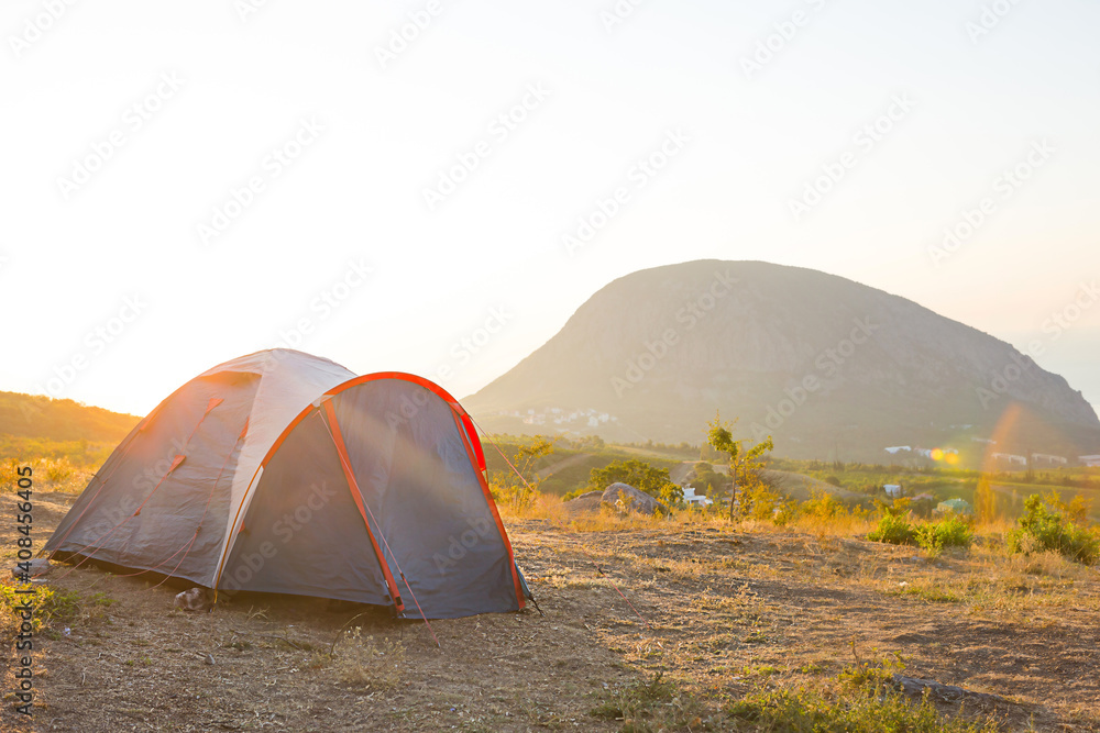 Installed tourist tent in the mountains with a view of the sea and sunrise. Domestic tourism, active summer trip, family adventures. Ecotourism, camping, sports mountain hiking. Ayu-Dag, Crimea.