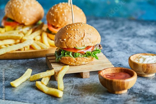 Cheeseburgers with fry potato on the wooden board