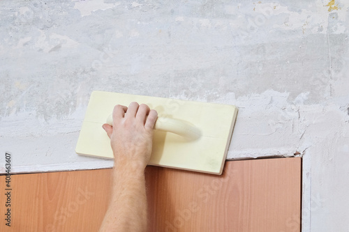 Male working polishes grinds wall. Plastering Float Trowel.