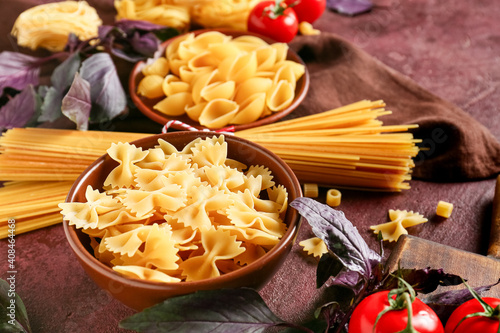 Assortment of dry pasta on color background