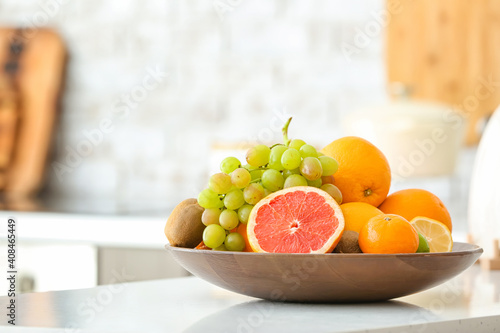 Fototapeta Naklejka Na Ścianę i Meble -  Plate with different fruits on kitchen table