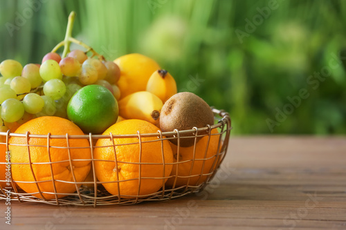 Basket with different fruits on table outdoors