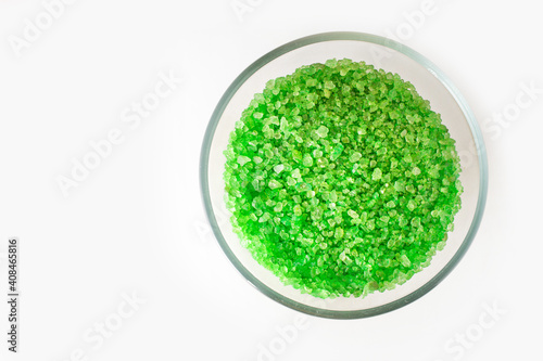 top view. glass bowl with bath salt, emerald green. on white background. relaxation rest and treatment concept.