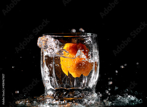 tangerine in water with splashes on black background