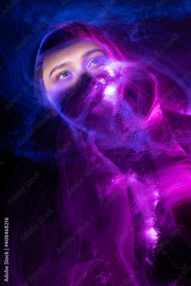 Portrait of young woman amid light painting , Over Black Background. Long exposure photo without photoshop, light drawing at long exposure Portrait of young woman amid light painting , Over Black Background. Long exposure photo without photoshop, light drawing at long exposure