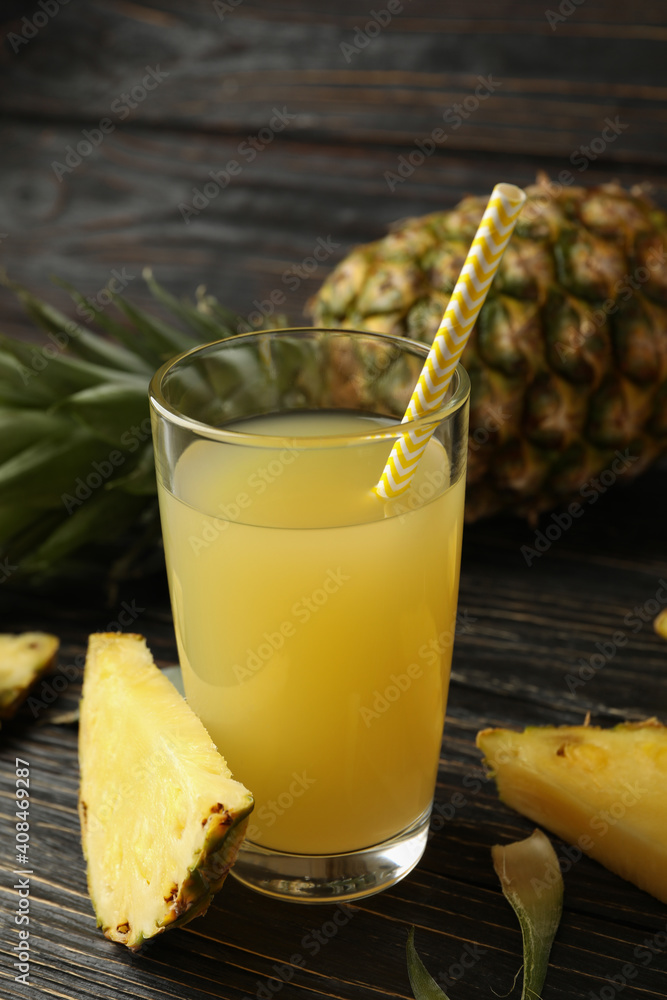Ripe pineapple and glass of juice on wooden background Ripe pineapple and glass of juice on wooden background