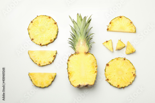 Flat lay with pineapple and slices on white background