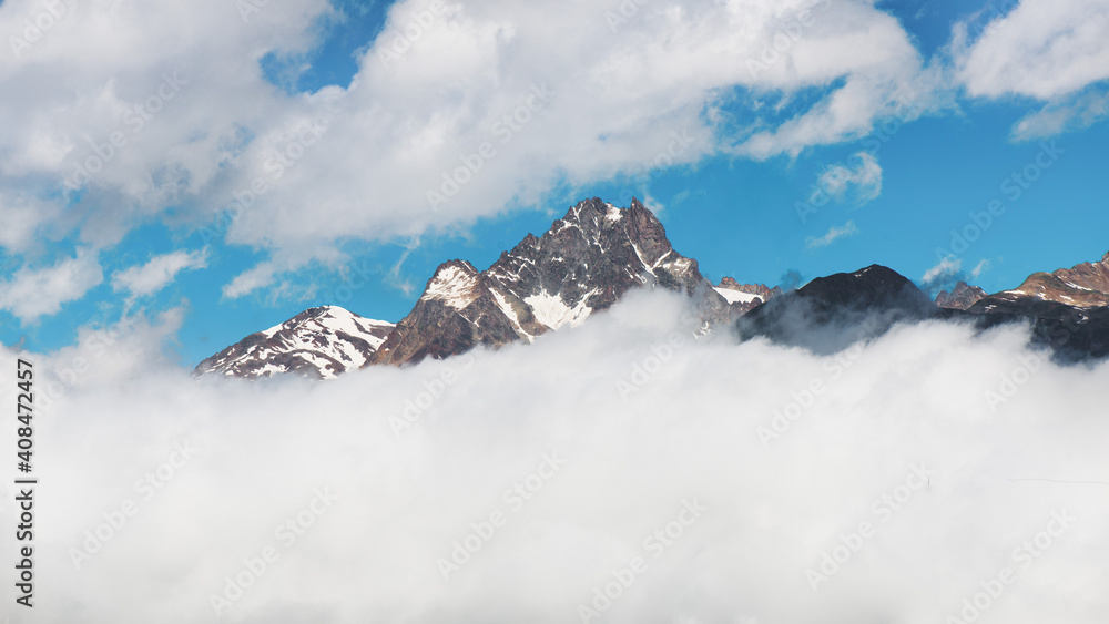 Obraz premium Mountain top panorama coming out of the clouds