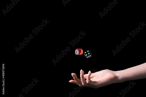 Female hand rolling dices isolated on black background. Horizontal view. Mock up with copy space for your text