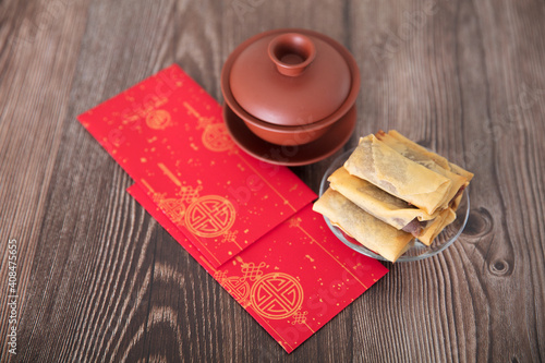 Fried spring rolls, tea and red envelopes on the table at the beginning of spring in China photo