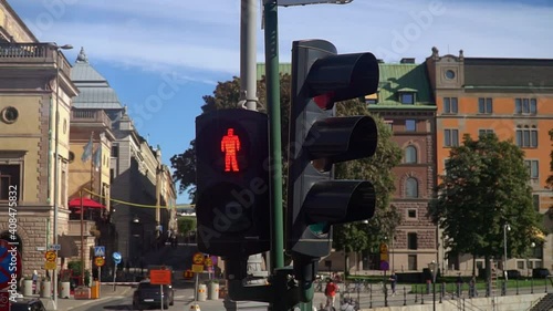 Traffic light for pedestrians on the road is lit in red