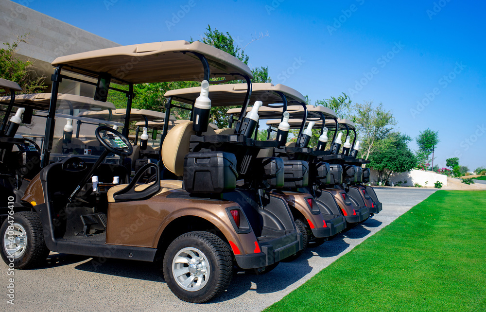 Background image of Golf carts parked on a golf closure in a line.