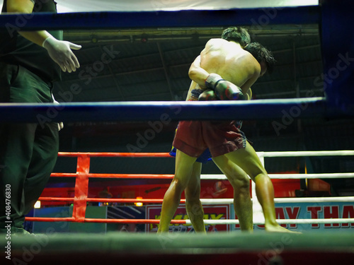 Bild auf Leinwand Two aggressive Thai boxing fighters / boxers are fighting and clinching each oth